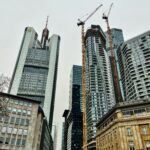 Modern skyscrapers and construction cranes in Frankfurt am Main's bustling cityscape.
